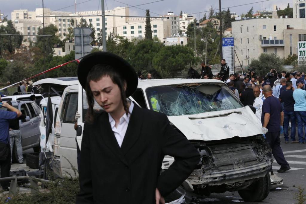 Ultraortodox fiú a merényletetben részt vevő furgon előtt (fotó Ammar Awad, Reuters, forrás news.yahoo.com)