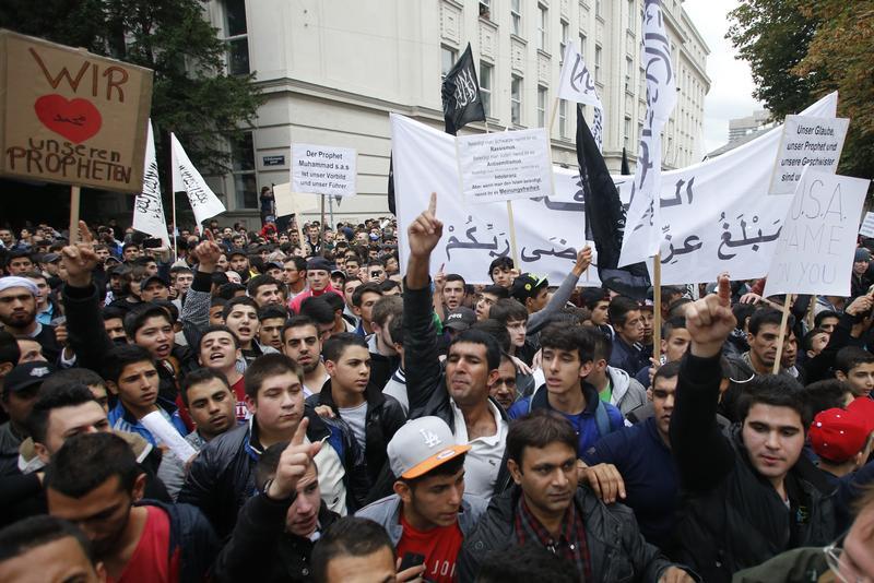 Austrian Muslims carry banners and shout slogans during a protest against a film made in the U.S. and cartoons published by a French magazine that denigrate Islam's Prophet Mohammad, in Vienna September 22, 2012. REUTERS/Leonhard Foeger (AUSTRIA - Tags: CIVIL UNREST RELIGION) - RTR38A9P